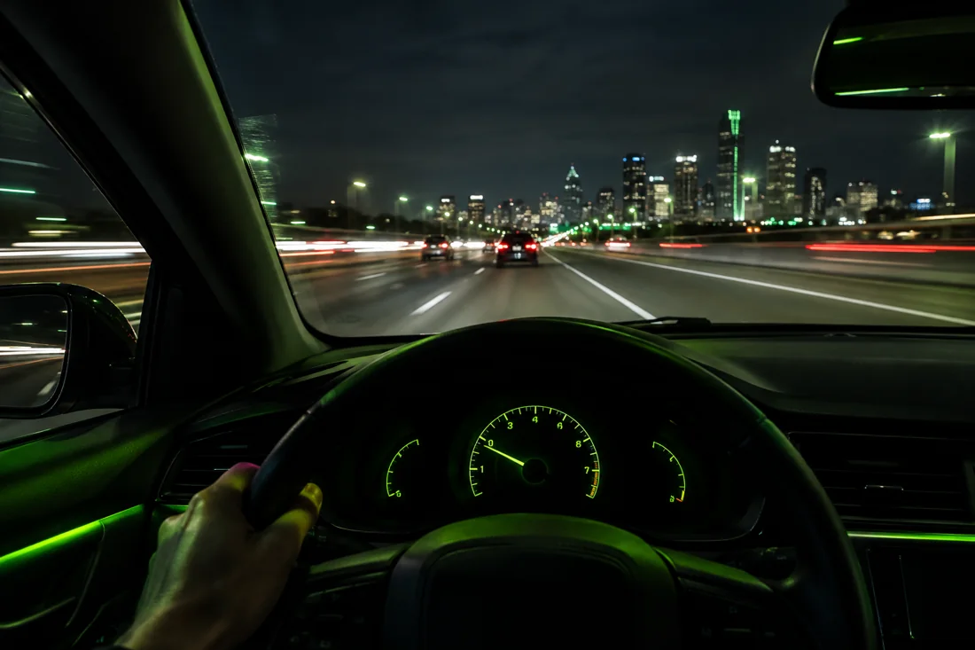 Driver's view leaving the city at night on the highway